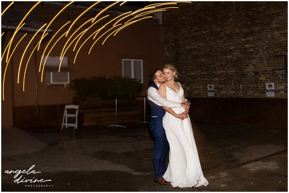 bride and groom posing under lights