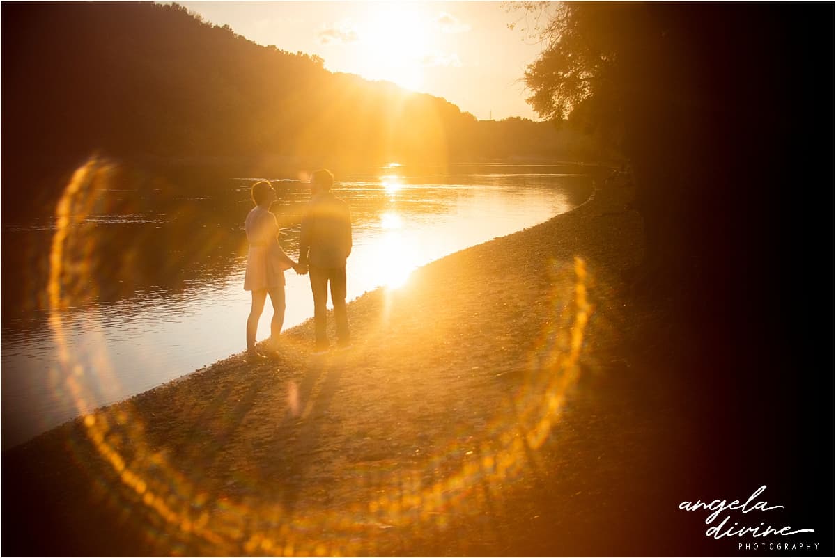 engaged couple holding hands watching sunset