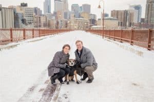 couple with dog in front of city skyline