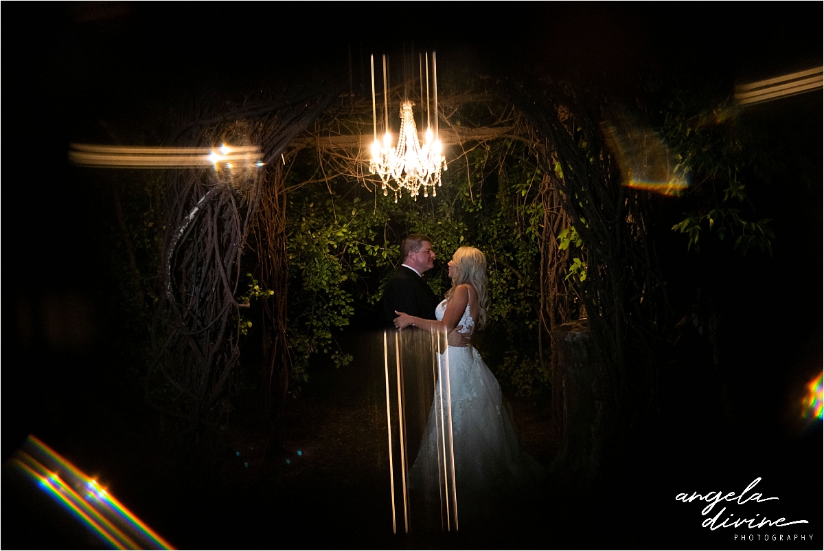 bride and groom dancing outside under lights