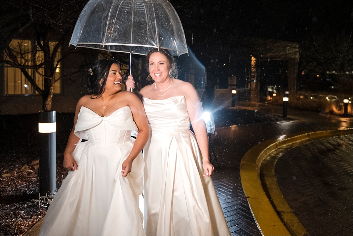 Minneapolis Marriott Southwest brides pose with umbrella outside at night